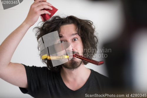 Image of Portrait of a man in party hat blowing in whistle