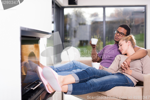 Image of Young multiethnic couple  in front of fireplace