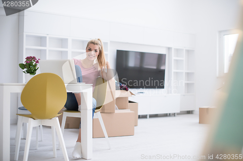 Image of Young woman moving in a new home