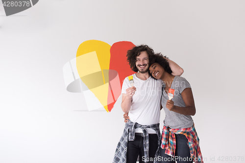 Image of couple with painted heart on wall