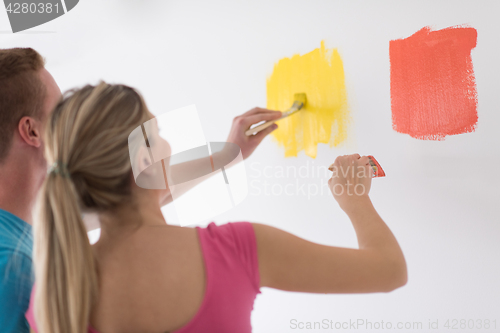 Image of couple painting interior wall