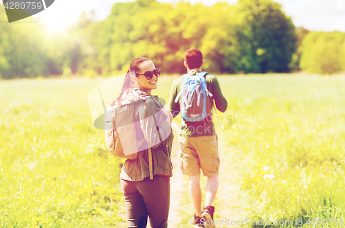 Image of happy couple with backpacks hiking outdoors