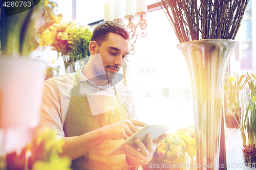 Image of man with tablet pc computer at flower shop