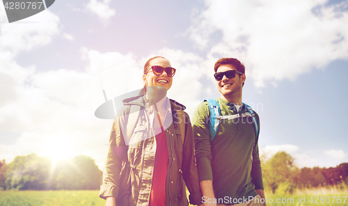 Image of happy couple with backpacks hiking outdoors