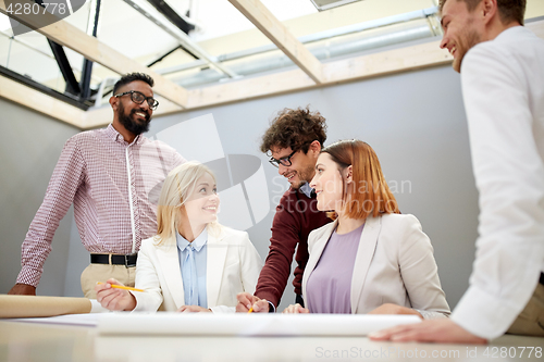 Image of business team with blueprint project at office