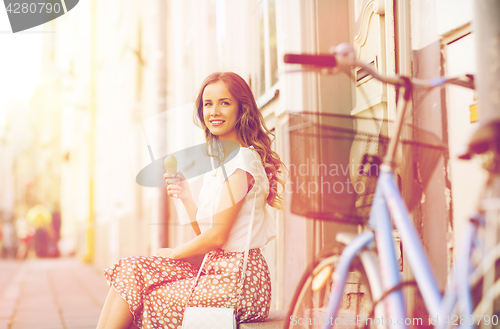 Image of happy woman with bike and ice cream