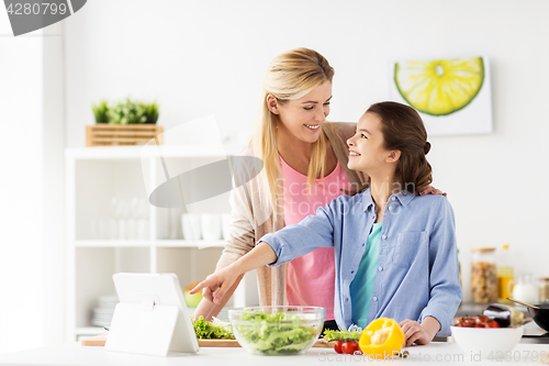 Image of family cooking dinner using tablet pc at kitchen