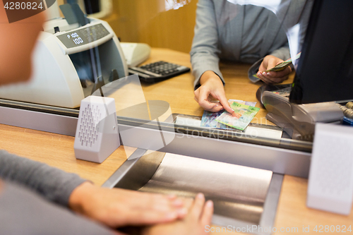 Image of clerk counting cash money at bank office