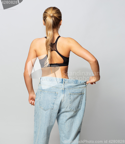 Image of young slim sporty woman in oversize pants