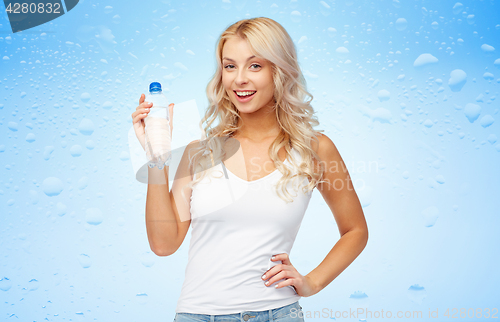 Image of happy beautiful young woman with bottle of water