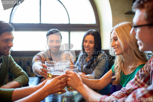 Image of happy friends drinking beer at bar or pub