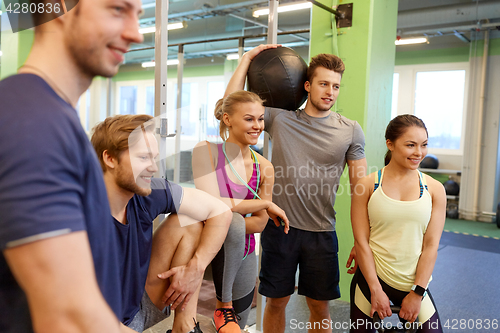 Image of group of friends with sports equipment in gym