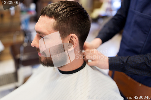 Image of hairdresser and man with beard at barbershop