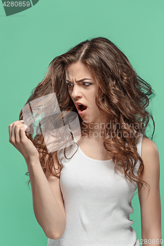 Image of Frustrated young woman having a bad hair on blue