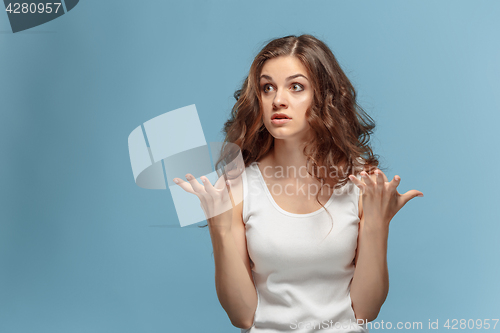 Image of Portrait of an angry woman looking away on a blue background