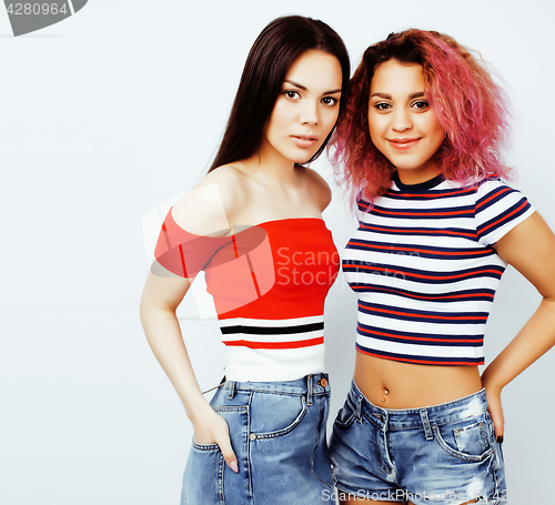 Image of lifestyle people concept: two pretty stylish modern hipster teen girl having fun together, diverse nation mixed races, happy smiling making selfie