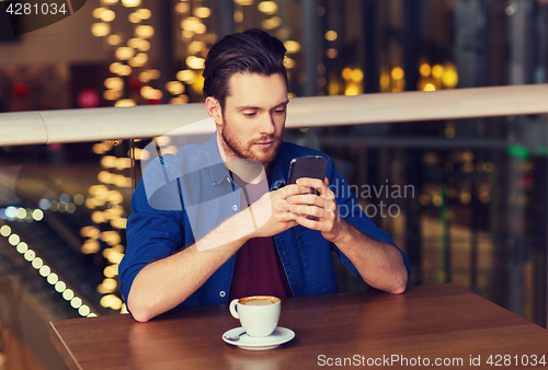 Image of man with smartphone and coffee at restaurant