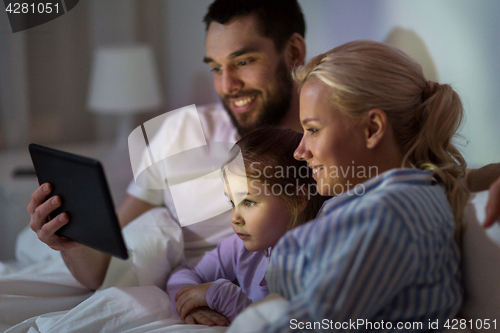 Image of happy family with tablet pc in bed at home