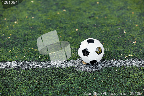 Image of soccer ball on football field marking line