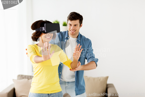 Image of happy couple with virtual reality headset at home
