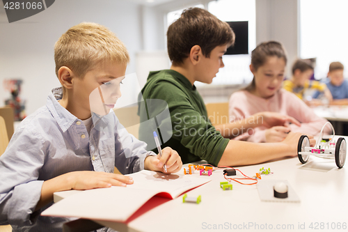 Image of happy children building robots at robotics school