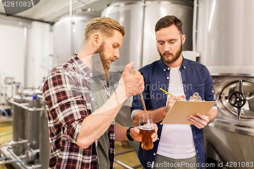 Image of men with pipette testing craft beer at brewery