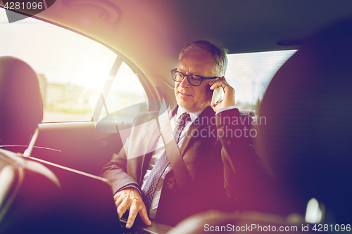 Image of senior businessman calling on smartphone in car