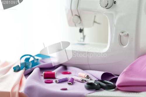 Image of sewing machine, scissors, buttons and fabric