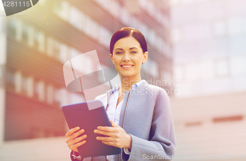 Image of smiling business woman with tablet pc in city