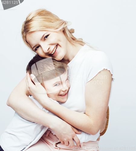 Image of young modern blond mother with cute son together happy smiling family posing cheerful on white background, lifestyle people concept, sister and brother friends 