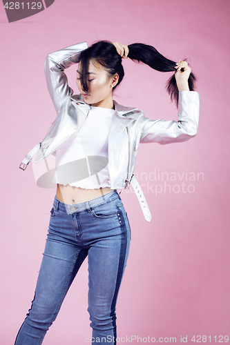 Image of young pretty smiling asian korean girl wearing modern fashion clothers on pink background, lifestyle people concept