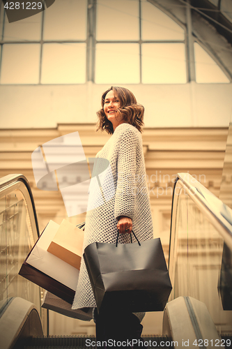 Image of Smiling happy middle-aged woman with shopping bags 