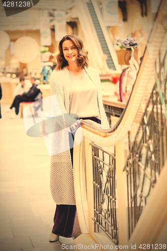 Image of Smiling woman in a knitted bright summer coat