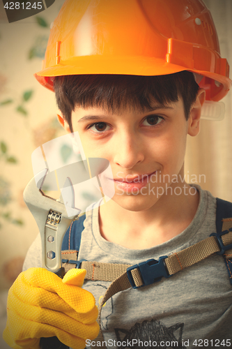 Image of Boy in a protective helmet and with a wrenc