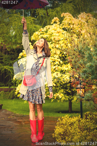 Image of fashion. Beautiful woman with umbrella in the rain