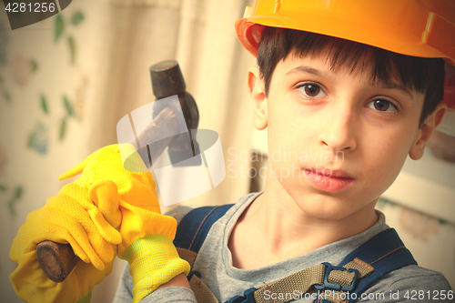 Image of boy in a protective helmet and with a hammer 