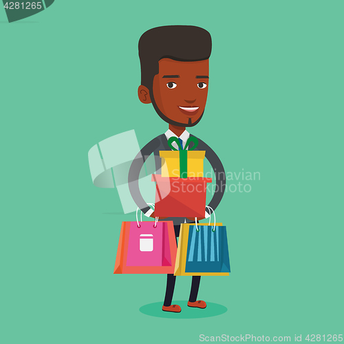 Image of Happy man holding shopping bags and gift boxes.