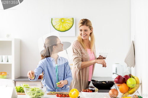 Image of happy family cooking salad at home kitchen