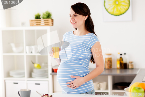 Image of happy pregnant woman having breakfast at home