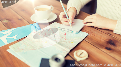 Image of close up of traveler hands with notepad and pencil