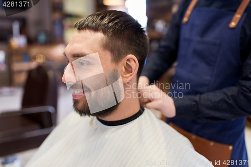 Image of hairdresser and man with beard at barbershop