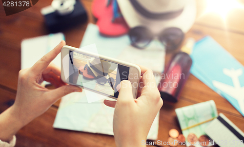 Image of close up of woman with smartphone and travel stuff
