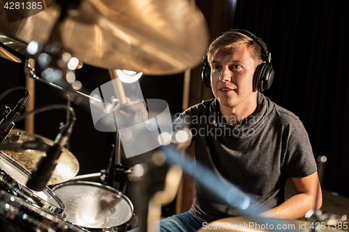 Image of male musician playing drums and cymbals at concert