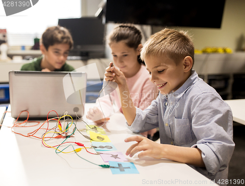 Image of kids, laptop and invention kit at robotics school