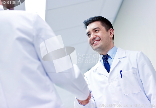 Image of smiling doctors at hospital doing handshake