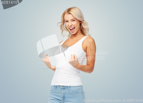 Image of happy young woman doing fist pump gesture