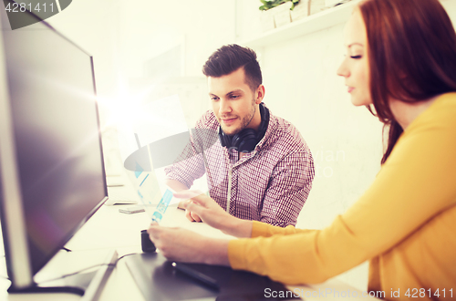 Image of happy creative team with papers at office