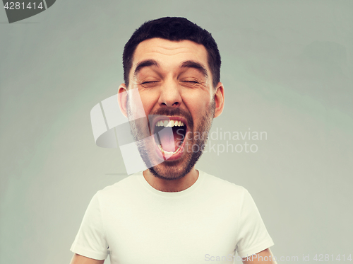 Image of crazy shouting man in t-shirt over gray background