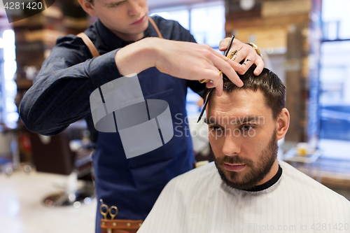 Image of man and barber cutting hair at barbershop