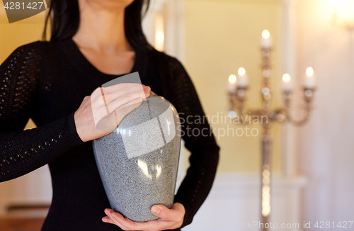 Image of close up of woman with cremation urn in church